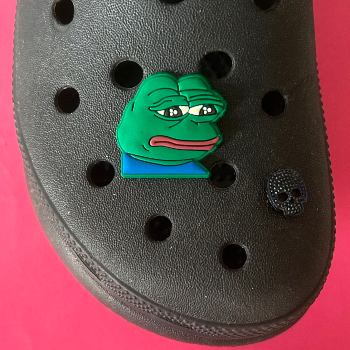 Sad Frog Meme croc like shoe charm. Shown on a black croc shoe. 