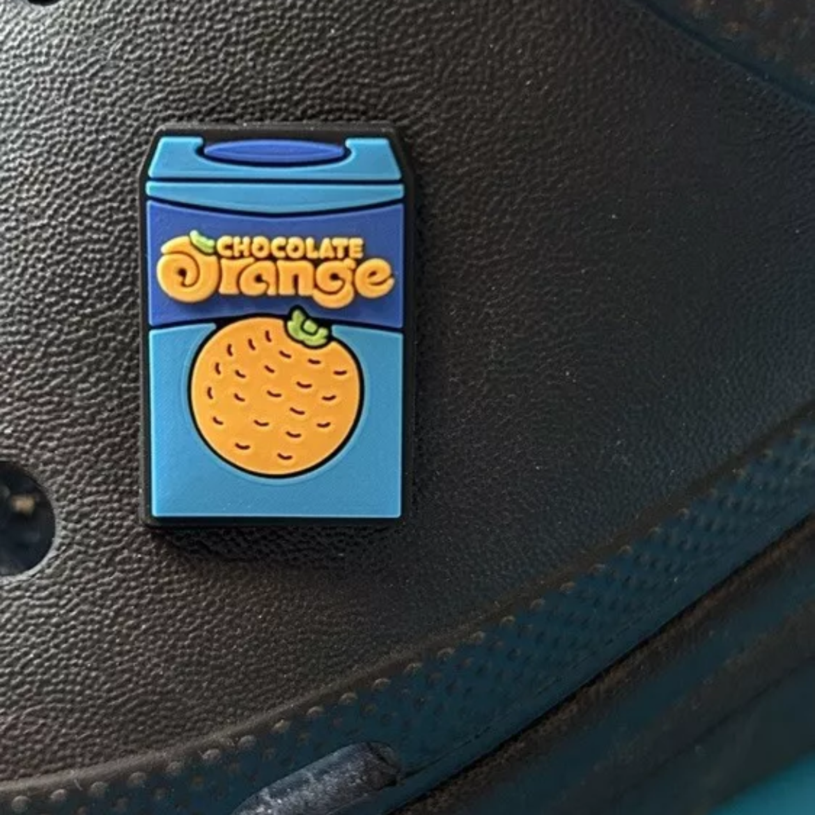 Chocolate Orange croc like shoe charm. Shown on a black croc shoe. 