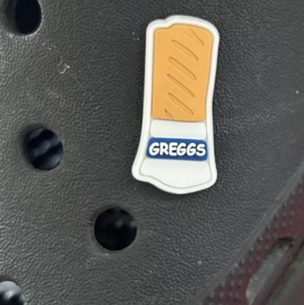 Sausage Roll croc like shoe charm. Shown on a black croc shoe. 