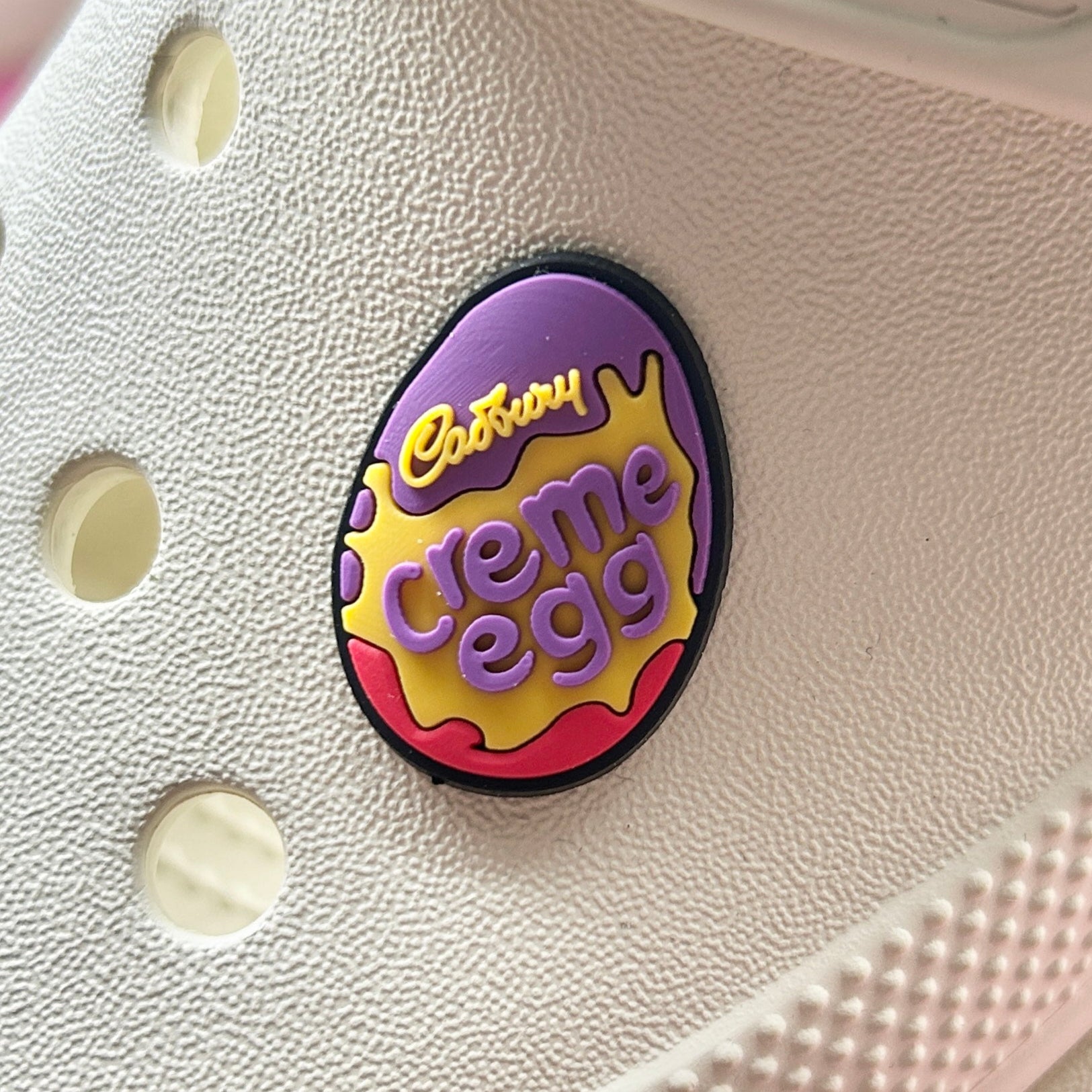 Chocolate egg with creme croc like shoe charm. Shown on a cream croc shoe. 