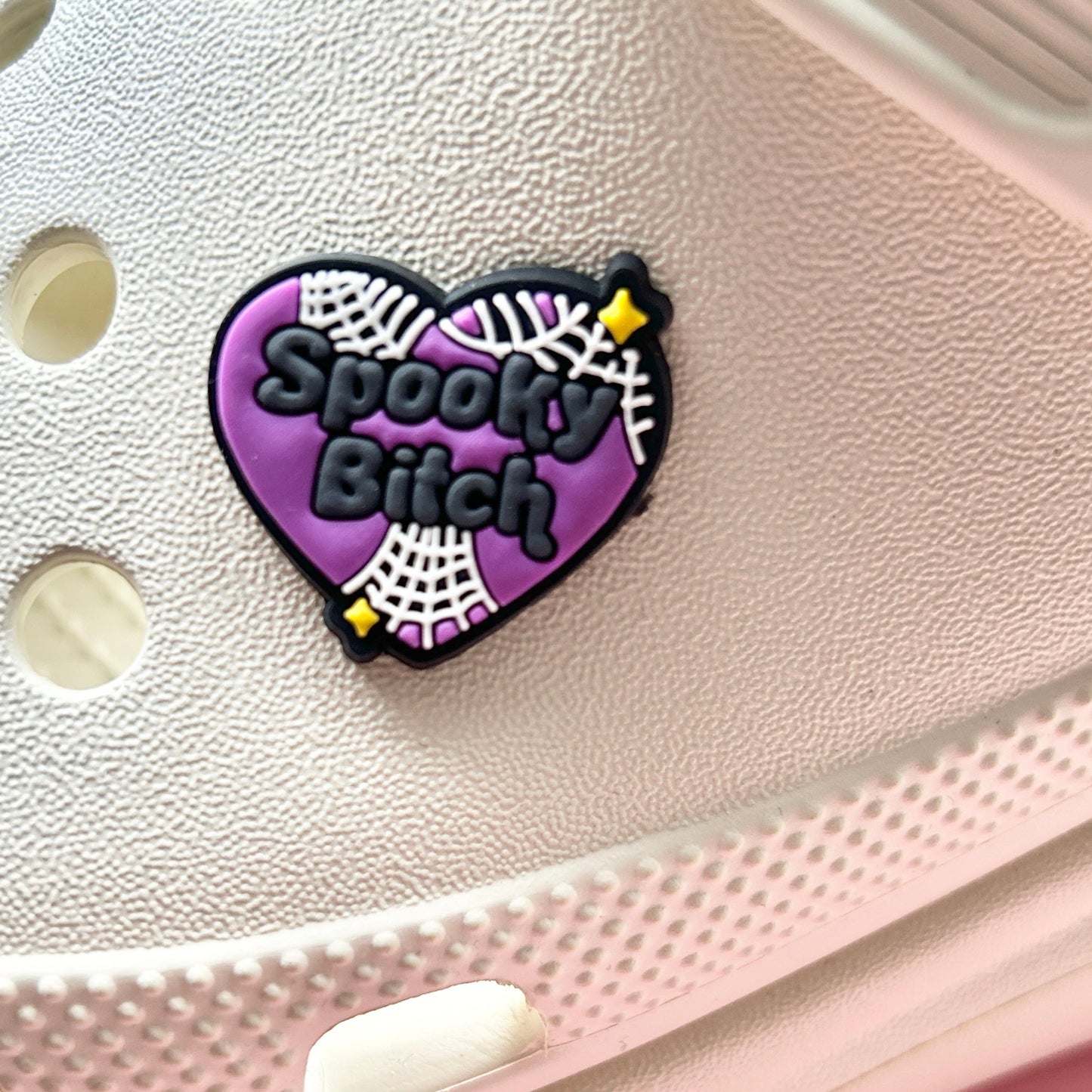 Spooky Bitch croc like shoe charm. Shown on a cream croc shoe. 