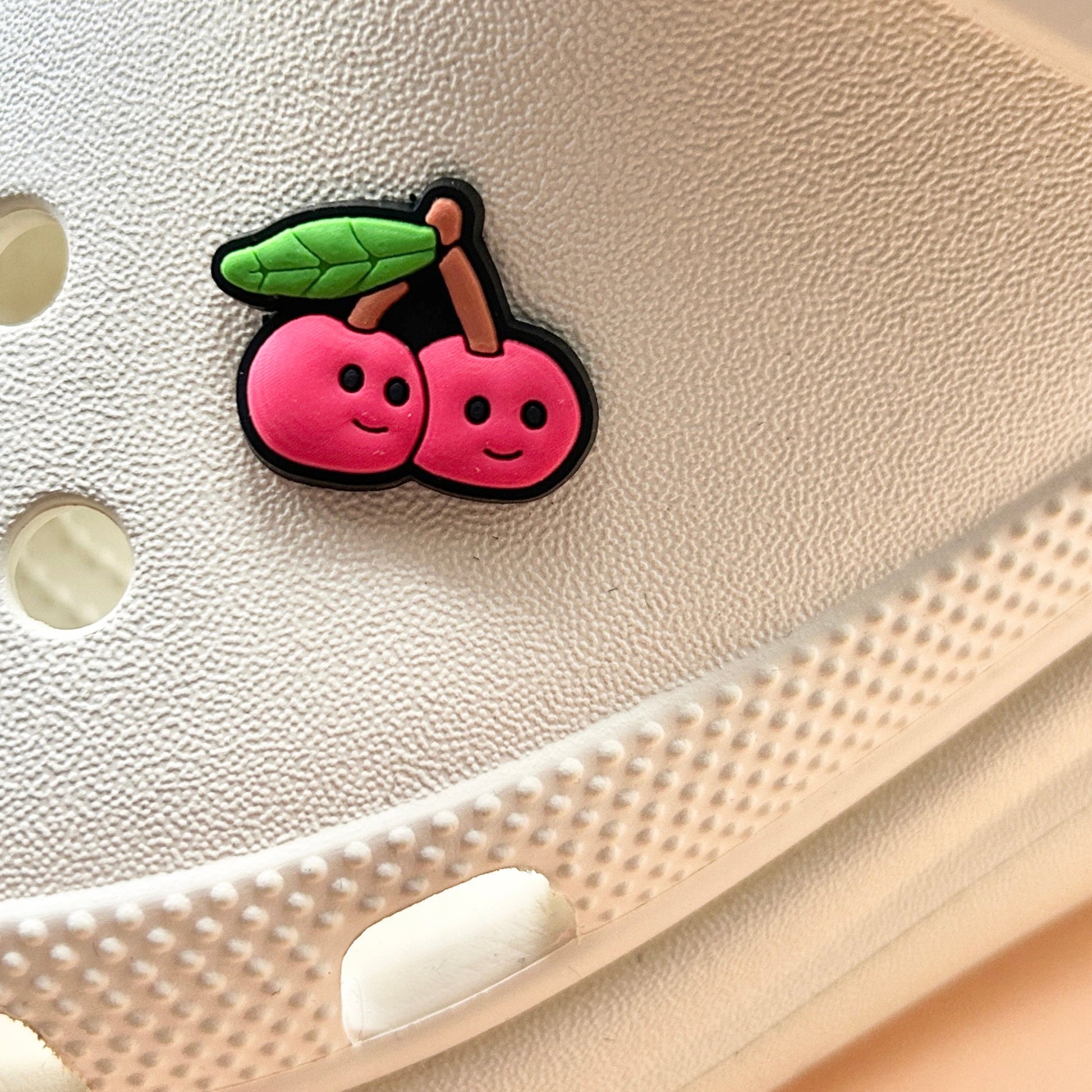 Smiley Cherries croc like shoe charm. Shown on a cream croc shoe. 