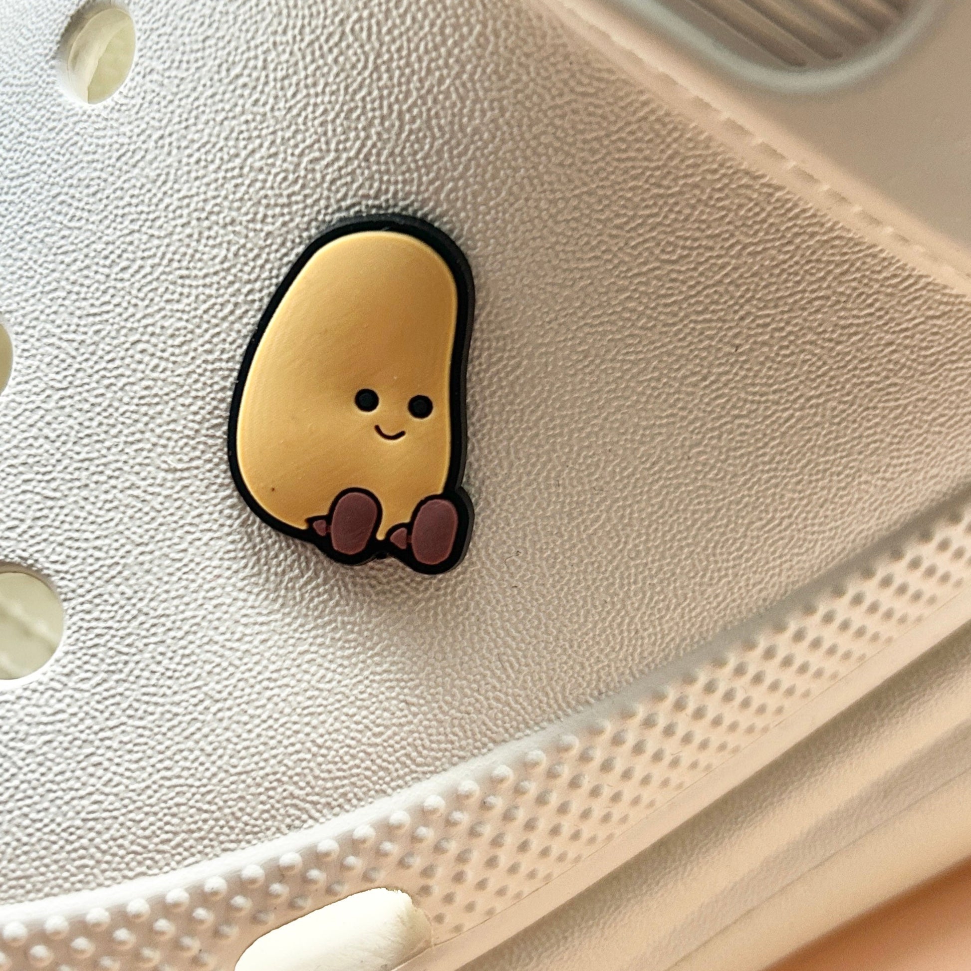 Potato croc like shoe charm. Shown on a cream croc shoe.