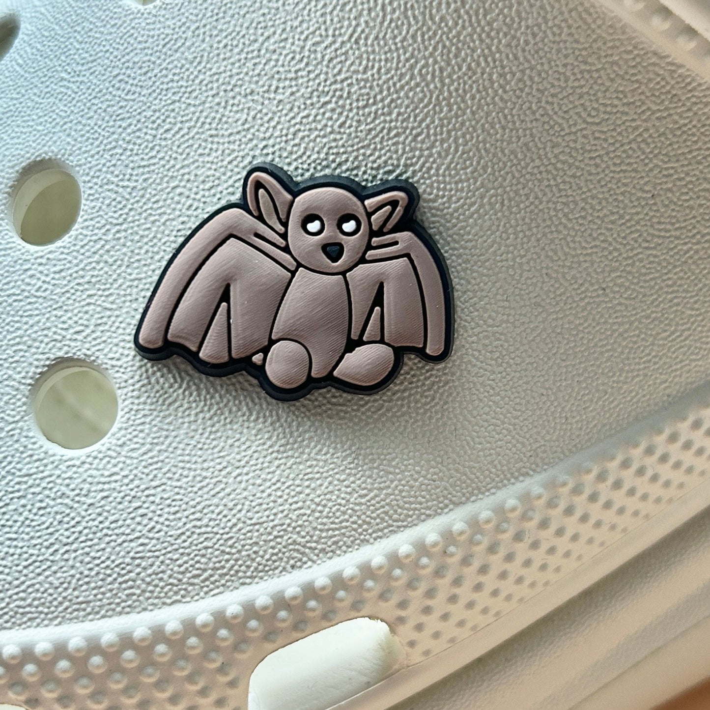 Brown Bat croc like shoe charm. Shown on a cream croc shoe. 