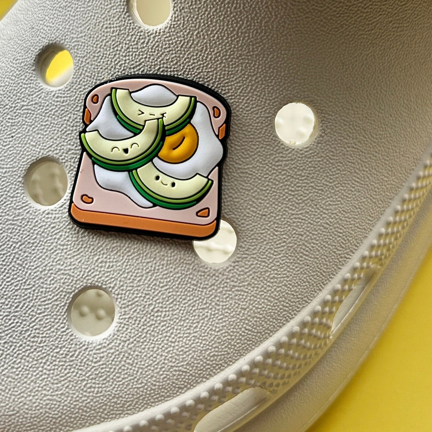 Smiley Avocado and Egg on toast croc like shoe charm shown on a cream croc shoe. 