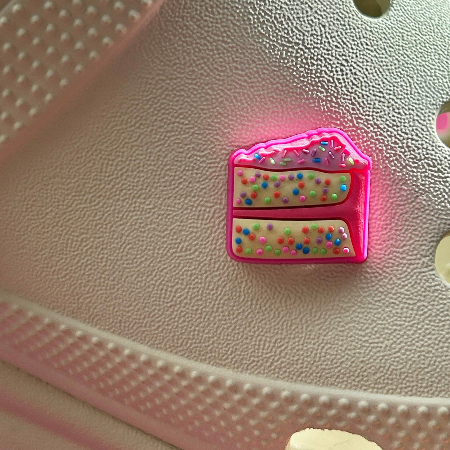 Speckle Cake Croc shoe charm. Shown on a cream croc shoe. Pink and multicolour. 