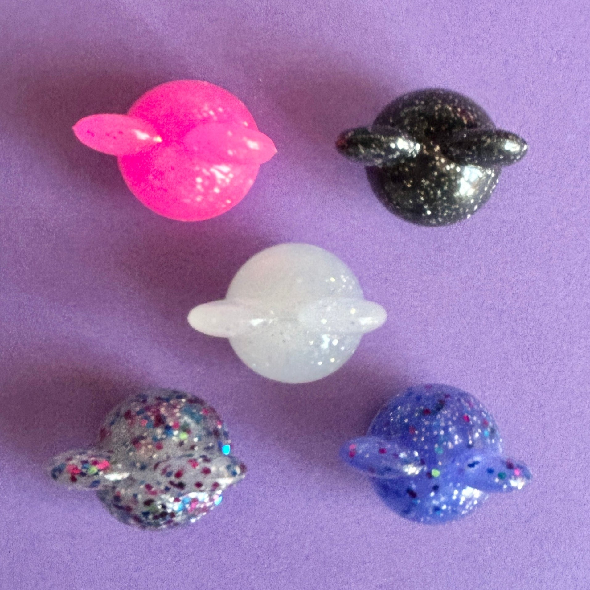 3D Glitter mouse ears croc charm. Available in 5 different colours. Top down view on a purple background. 