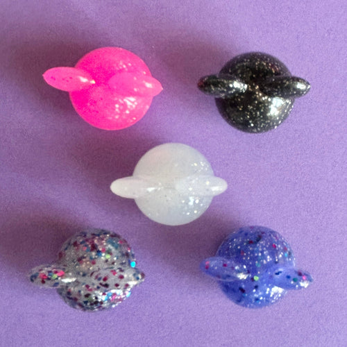 3D Glitter mouse ears croc charm. Available in 5 different colours. Top down view on a purple background. 