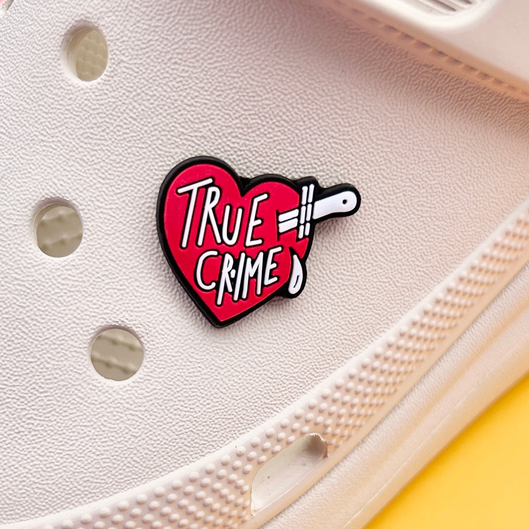 True Crime Lover Slogan croc like shoe charm. Red and White shown on a cream croc shoe. 
