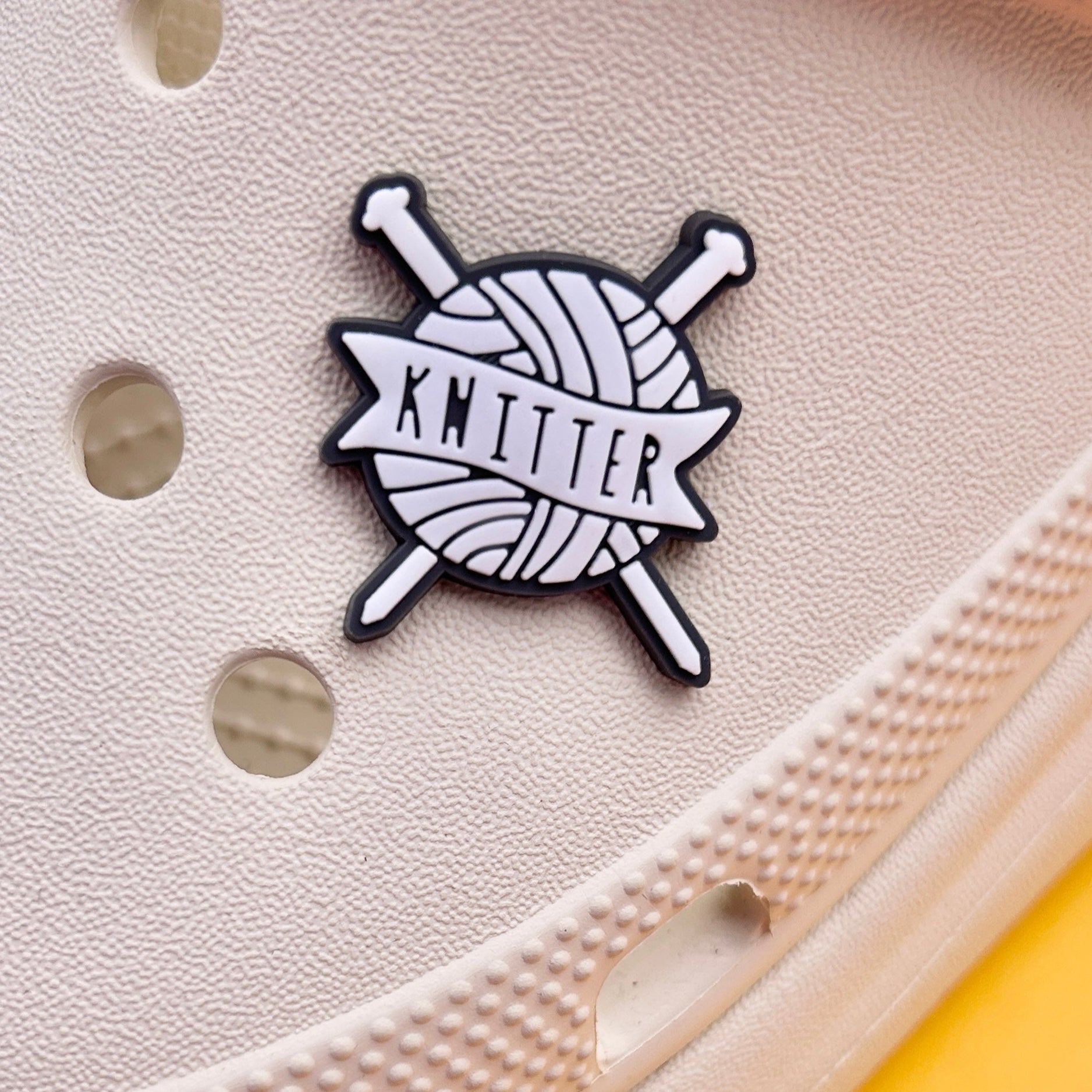 Knitter slogan ball of wool croc like shoe charm. Shown on a cream croc shoe. 