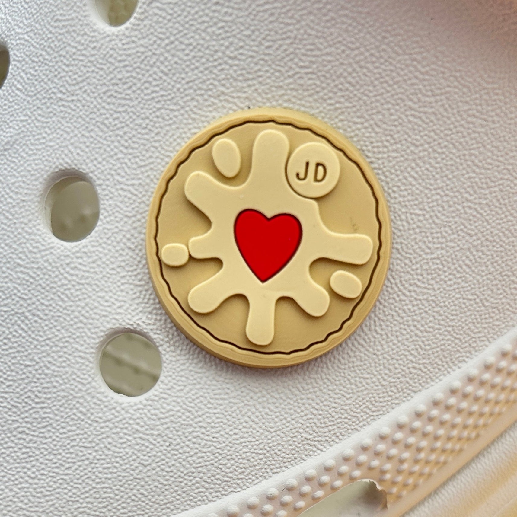 Jammy Biscuit shoe charm. Shown on a cream croc shoe. 