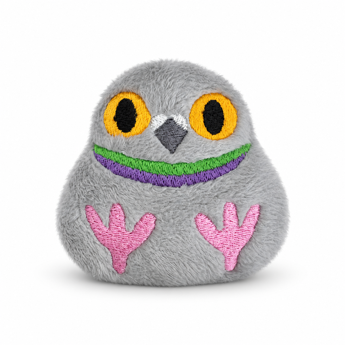 A gray plush pigeon toy with embroidered yellow eyes, a gray beak, a green and purple stitched smile, and pink feet, shown on a clean white background.