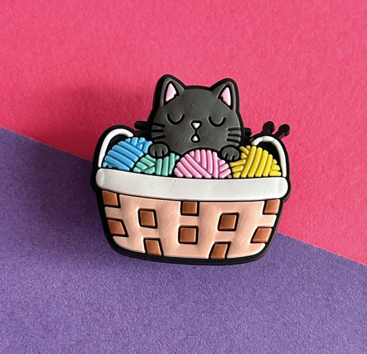 Black cat in a basket of wool croc like shoe charm. 