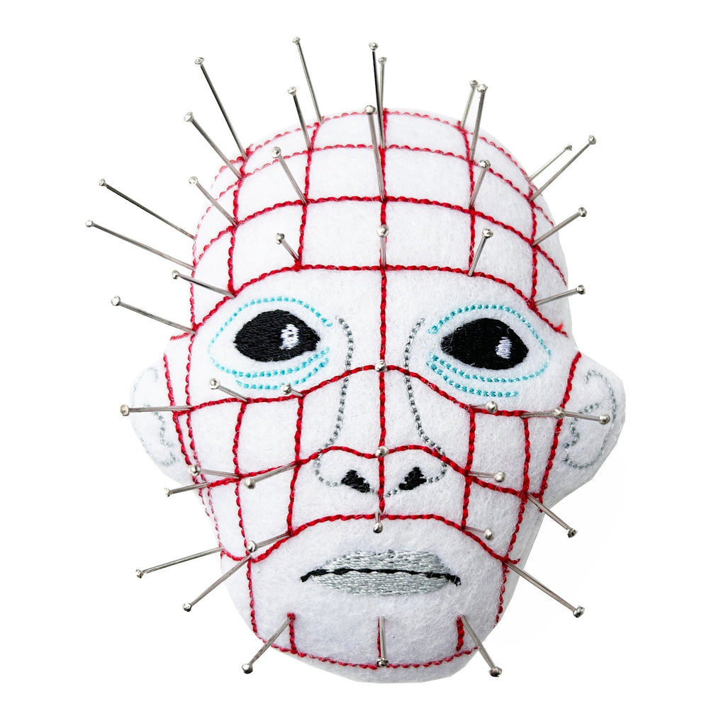 Pinhead from hellraiser pin cushion with pins. White background.